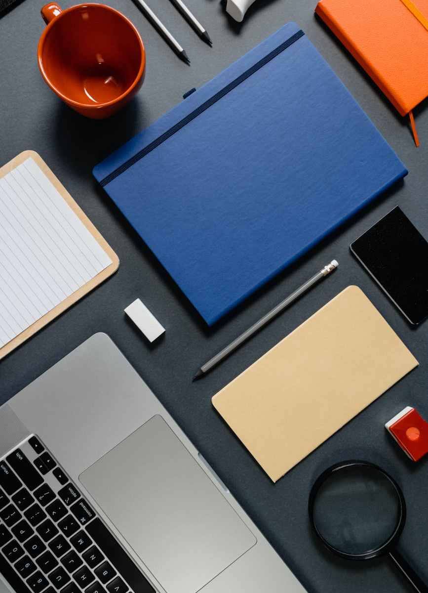 a flatlay of a laptop and office supplies